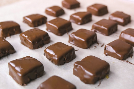 Handmade chocolate candies on baker sheet. Production of chocolate candies.