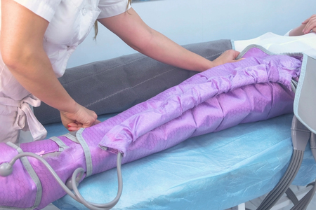Woman at the clinic for the treatment of pressure therapy procedure. Preparing to procedure with a doctor.の写真素材