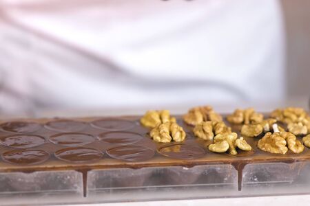 Preparing homemade chocolate candies with walnuts at home.の写真素材