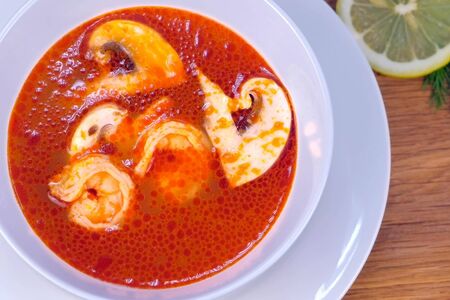 Prawn soup with mushrooms,Tom Yam Kung, thai food on wooden table, side viewの写真素材