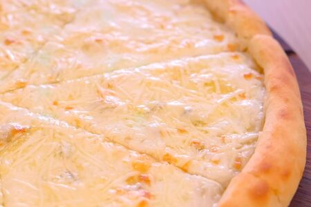 Half of slicing pizza with different types of cheese close-up viewの写真素材
