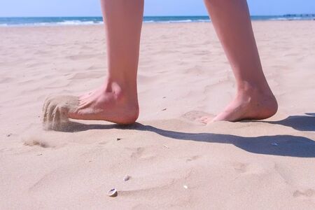Woman tourist walks barefooted on sand at sea beach resting on vacation. Tourism and travel concept....