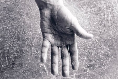 Water drains from the mans hand. Psychological problems concept. Hand close-up. Time concept. Black...