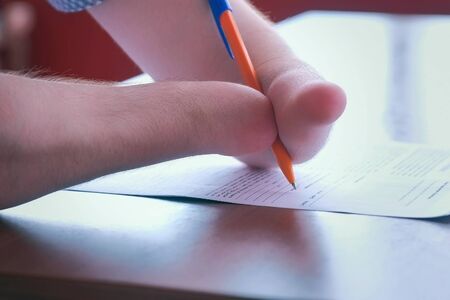 Problem of adaptation to usual life guy without wrists. Writing and paper work. Disabled man with two amputated stump hands meets friend signs documents, Hands closeup. Invalid with disabilities.の写真素材
