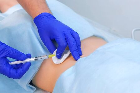 Surgeon in gloves gives injection of local anesthesia to patient before laser removing mole on back, closeup view. One day surgery concept. Removing nevus or birthmark. Cosmetic treatment.の写真素材