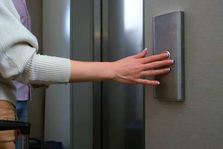Hand of woman pressing the button of elewator and waiting it. Female hand pushing the button of lift...