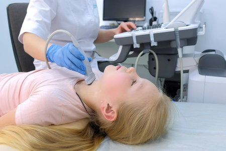 Doctor examining patient child girl thyroid gland using ultrasound scanner machine, closeup view. Woman runs ultrasound sensor over patients neck in clinic. Diagnostic examination.の写真素材