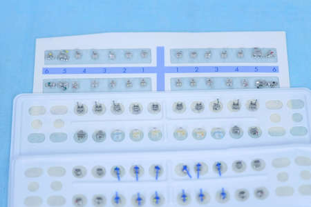 Metal braces different size for installing construction on teeth in plastic packaging. New braces in...