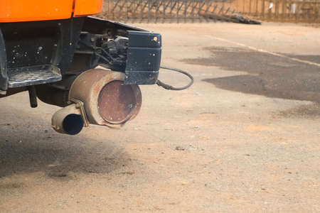 Close-up exhaust pipe of working construction machine on construction site. Construction, building...