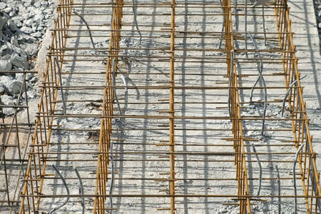 Ground floor of building under construction waits for concrete slab pouring. Rusty metal wiring is laid on the ground of house under construction. Preparation for making foundation of a building.の写真素材