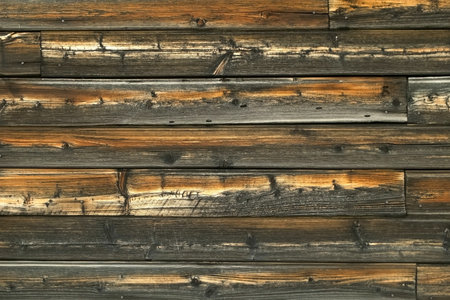 Close-up view of old wooden wall of rusty house. Beautiful wooden texture.