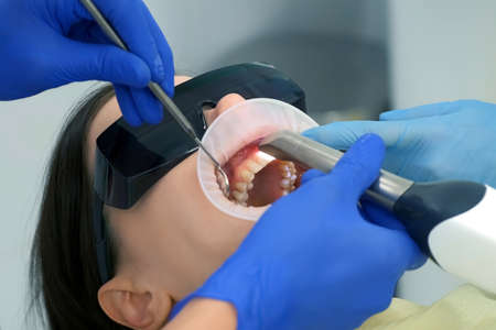Dentist is doing intraoral scanning for woman before installing ceramic veneers and crowns....