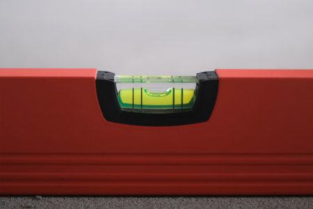 Red balance ruler, measurement horizontal deviation of construction. Bubble level ruler close up...