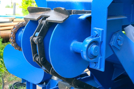 Mechanism of industrial conveyor belt for moving logs from woodworking machine. Modern equipment for...