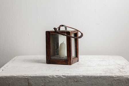 Vintage wooden lantern on white table against white wall. Vintage style.の写真素材