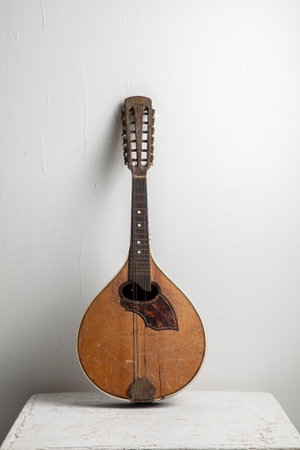 Vintage wooden balalaika on a white table against a white wallの写真素材