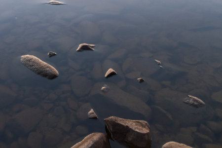 Pebbles in the water of the lake. Stones in the water.の写真素材