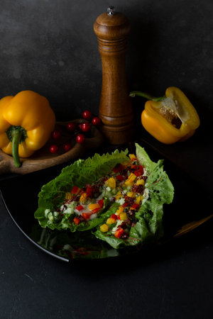 Vegetable salad with bell pepper, red and yellow peppers on black backgroundの写真素材