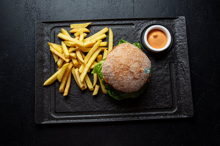 Homemade hamburger with French fries on black background, top viewの写真素材