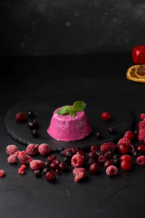 Panna Cotta with fresh raspberries and mint on black backgroundの写真素材