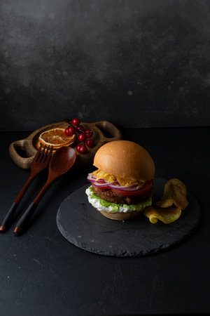 Tasty hamburger on a black slate plate. Dark background.の写真素材