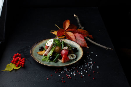 Salad with vegetables, cheese and olives on a black backgroundの写真素材