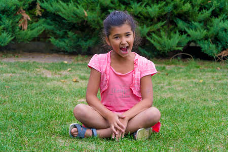 Small screaming gypsy child girl outside with little friend text on t-shirtの写真素材