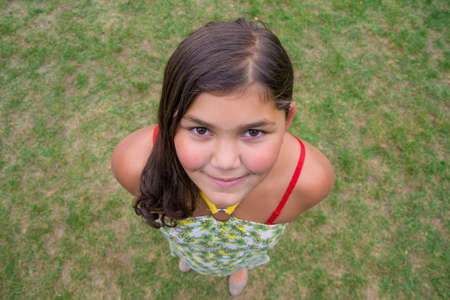 Child face smiling girl shot from above perspective in grassの写真素材