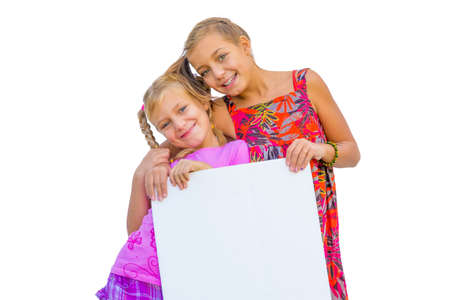 Happy smiling children girls holds blank banner or empty paper isolated on white backgroundの写真素材