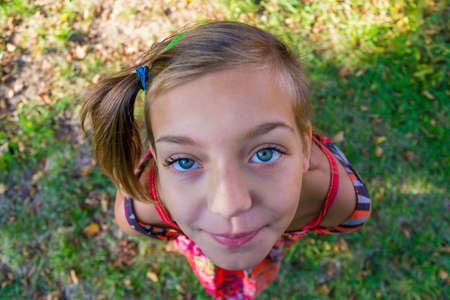Happy young child girl portrait face shot from above perspectiveの写真素材