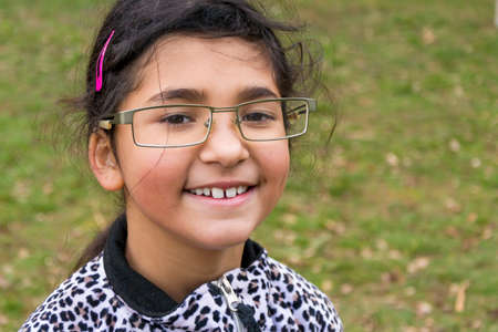 Funny happy smiling child girl wear too big glasses for fun