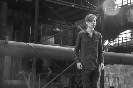 Vintage black and white photo of teenage boy labour in area of heavy industry ironworks workの写真素材