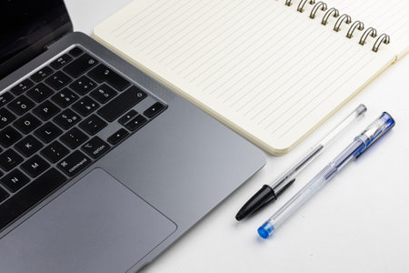 Laptop and notebook with pen on white background. Business concept.の写真素材