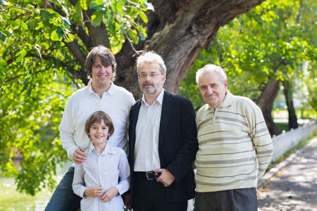 Four generations of men standing in a park の写真素材