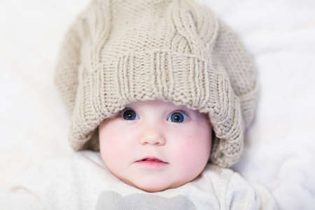 Little baby in a huge knitted hat の写真素材