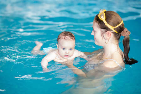 Little baby with blue eyes learning to swim の写真素材