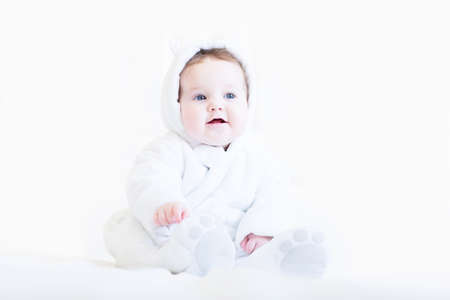 Sweet baby in a white teddy bear snow suit の写真素材