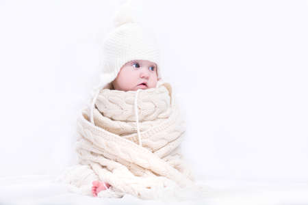 Cute baby in a big knitted scarf and hat の写真素材