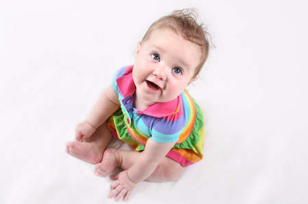 Funny happy baby in a colorful striped dress の写真素材