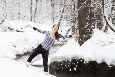 Young active pregnant woman walking in a snowy park の写真素材