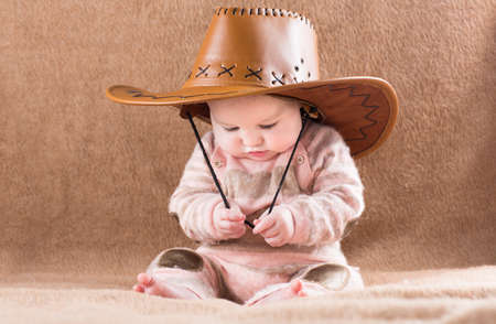 Funny baby in a big cowboy hat の写真素材