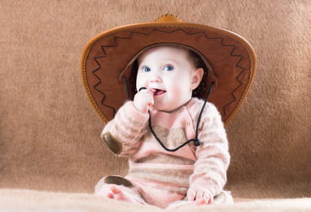 Beautiful little girl in a huge cowboy hat の写真素材
