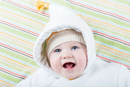 Happy laughing baby in a warm jacket with a funny hat の写真素材