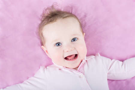 Portrait of a beautiful baby girl on pink background の写真素材