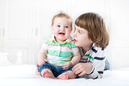 Cute boy talking to his baby sister 