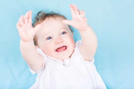 Funny little baby girl in a white dress の写真素材