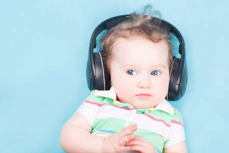 Funny little baby with big headphones の写真素材