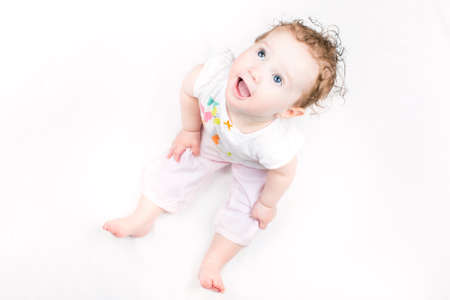 Beautiful little girl with curly hair on white background の写真素材