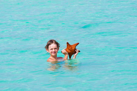 Little boy playing with a star fish の写真素材