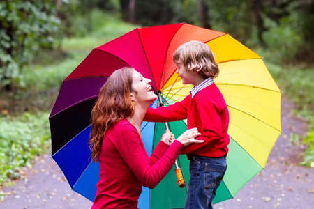 Mother and son playing under a colorful umbrella の写真素材